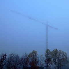 Construction site crane silhouette in the mist