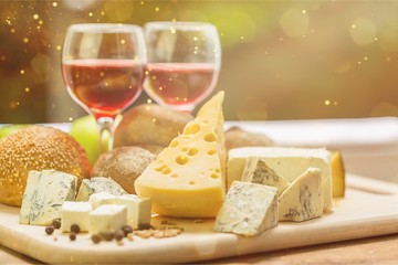 Assortment of cheese on board and two glasses of wine