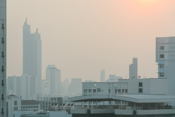 Air pollution effect made low visibility cityscape with haze and fog from dust in the air during sunset in Bangkok, Thailand.