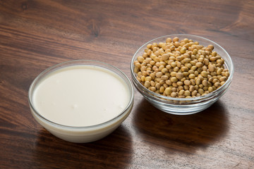 Food : Bowls of Soy Milk And  Soybeans Isolated on Wooden Background