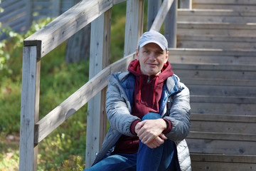Fototapeta premium Man sitting on the wooden stairs