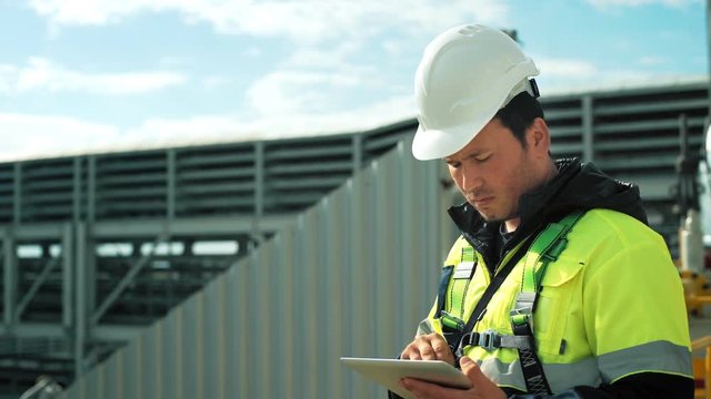 Professional male engineer during working outdoor using tablet pc medium close-up