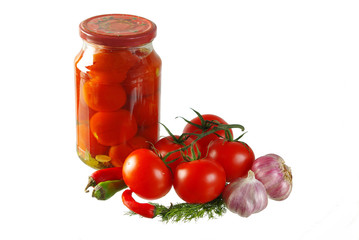 Jar of canned tomatoes and tomatoes on white background