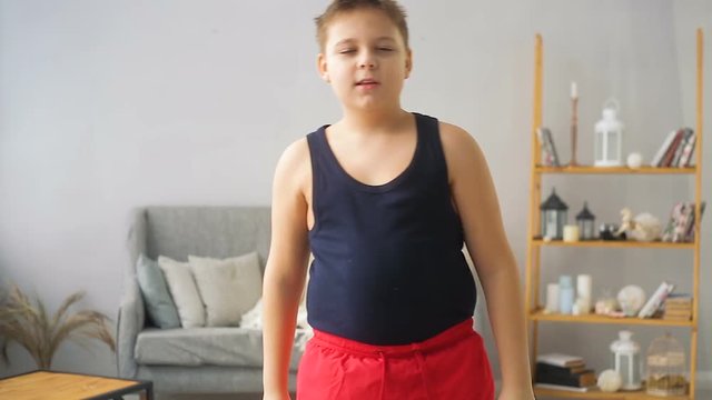 Fat boy doing exercises in the hall