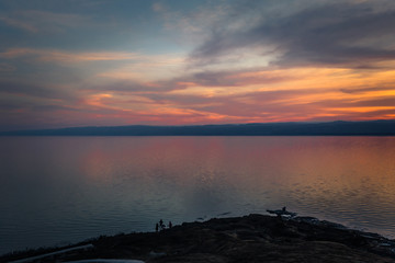 Fototapeta na wymiar Dead Sea - October 05, 2018: Tourists bathing in the salty Dead Sea by sunset, Jordan