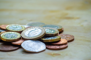 Coins stack on wood table in front of globe model. Concept for loan, property ladder, financial, mortgage, real estate investment, taxes and bonus.