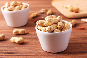 raw peanuts in shell on a wooden background.