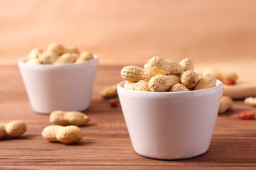 raw peanuts in shell on a wooden background.