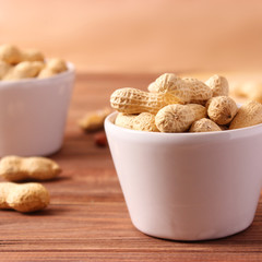 raw peanuts in shell on a wooden background.