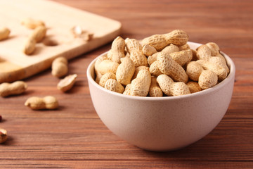 raw peanuts in shell on a wooden background.
