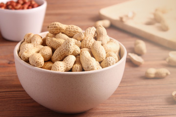 raw peanuts in shell on a wooden background.
