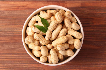 raw peanuts in shell on a wooden background.