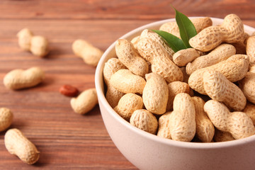 raw peanuts in shell on a wooden background.