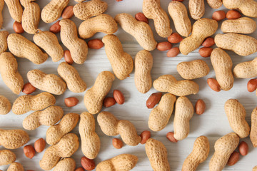 raw peanuts in shell on a wooden background.