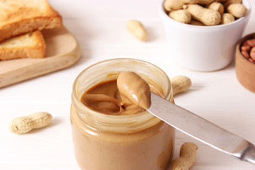  peanut butter and peanut beans on wooden background