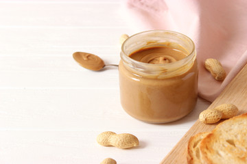  peanut butter and peanut beans on wooden background