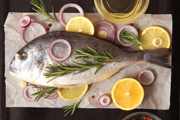  dorado fish with lemon and spices on wooden background