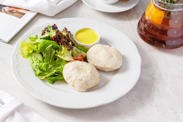 Steamed patties with fresh vegetables in a plate on the table