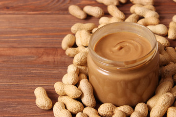  peanut butter and peanut beans on wooden background
