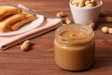  peanut butter and peanut beans on wooden background