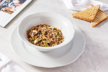 Buckwheat with mushrooms in a plate on the table