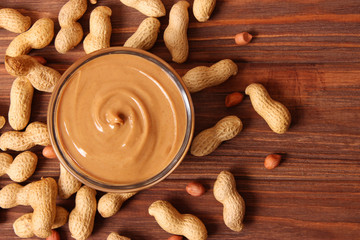  peanut butter and peanut beans on wooden background