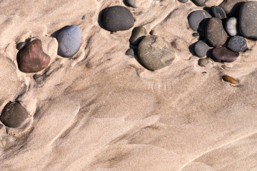 Fototapeta na wymiar Cradle Coast - Viele Steinchen im Sand