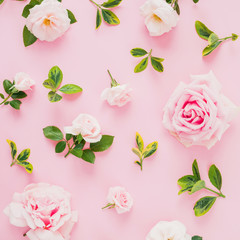 Pattern composition with roses flowers and leaves on pastel pink background. Flat lay, top view.