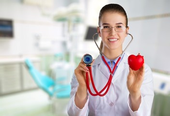 Attractive young female doctor with blurred hospital interior on