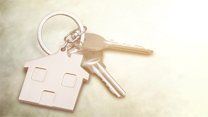Silver Home key with badge on wooden table