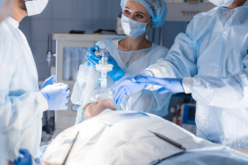 Team of experienced doctors and assistants performing difficult invasive surgery, using the chance...