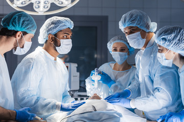 Female nurses putting oxygen mask on patient in operation room. Jaw thrust maneuver technique for give oxygen and medication via mask from ventilator machine