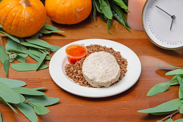 Meat cutlet with buckwheat in a plate on the table