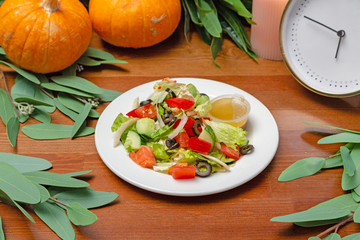 Fresh vegetable salad with sauce in a white plate on the table