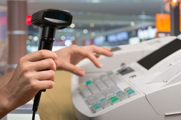 Cash register with LCD display and worker's hand holding receipt