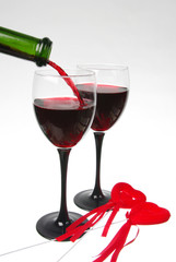 Red wine is poured into two glasses