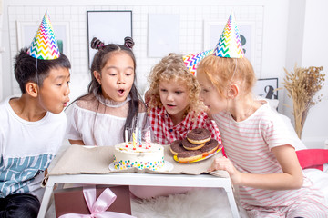 children helping their friend to blow out the candels. close up photo.