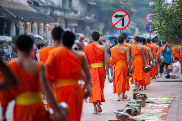 Buddhist novice monks with buddhist alms giving ceremony at Luang Prabang. - obrazy, fototapety, plakaty