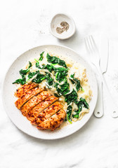 Baked chicken breast, mashed potatoes with creamy spinach on a light background, top view. Comfort food