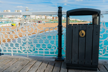Black wooden garbage on the seafront beach at the Brighton Pier for tourist and visitor. Save the ocean background concept.