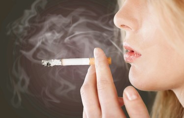 Portrait of the beautiful elegant girl smoking cigarette