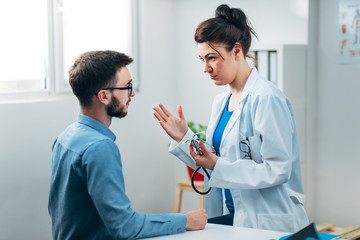 Woman Doctor talking to Patient at her Medical Office