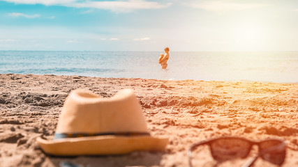 Hat and glasses on the sand on the beach