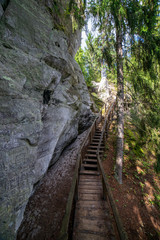 Fototapeta na wymiar tourist trail with wooden pathwalk and stairs near sandstone cliffs