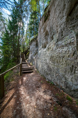 tourist trail with wooden pathwalk and stairs near sandstone cliffs