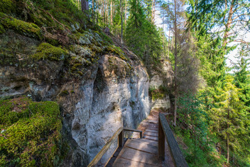 tourist trail with wooden pathwalk and stairs near sandstone cliffs