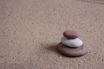 Fototapeta na wymiar relaxing stones laying on sand textured pattern