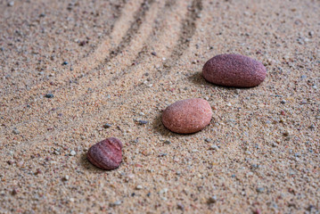 relaxing stones laying on sand textured pattern