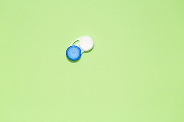 Container for contact lenses on green background, top view