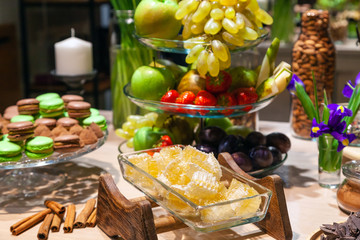Closeup of fresh honeycombs cut into cubes in transparent square glass bowl at buffet, cinnamon...